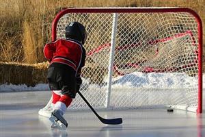 A young boy scoring an ice hockey goal